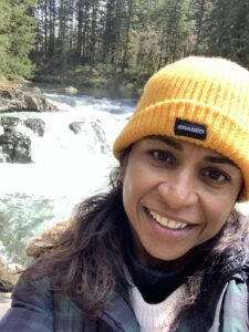 A woman in a yellow hat near some water