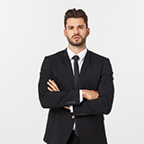 A man in a suit and tie standing with his arms crossed.