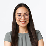 A woman with long hair wearing glasses and smiling.