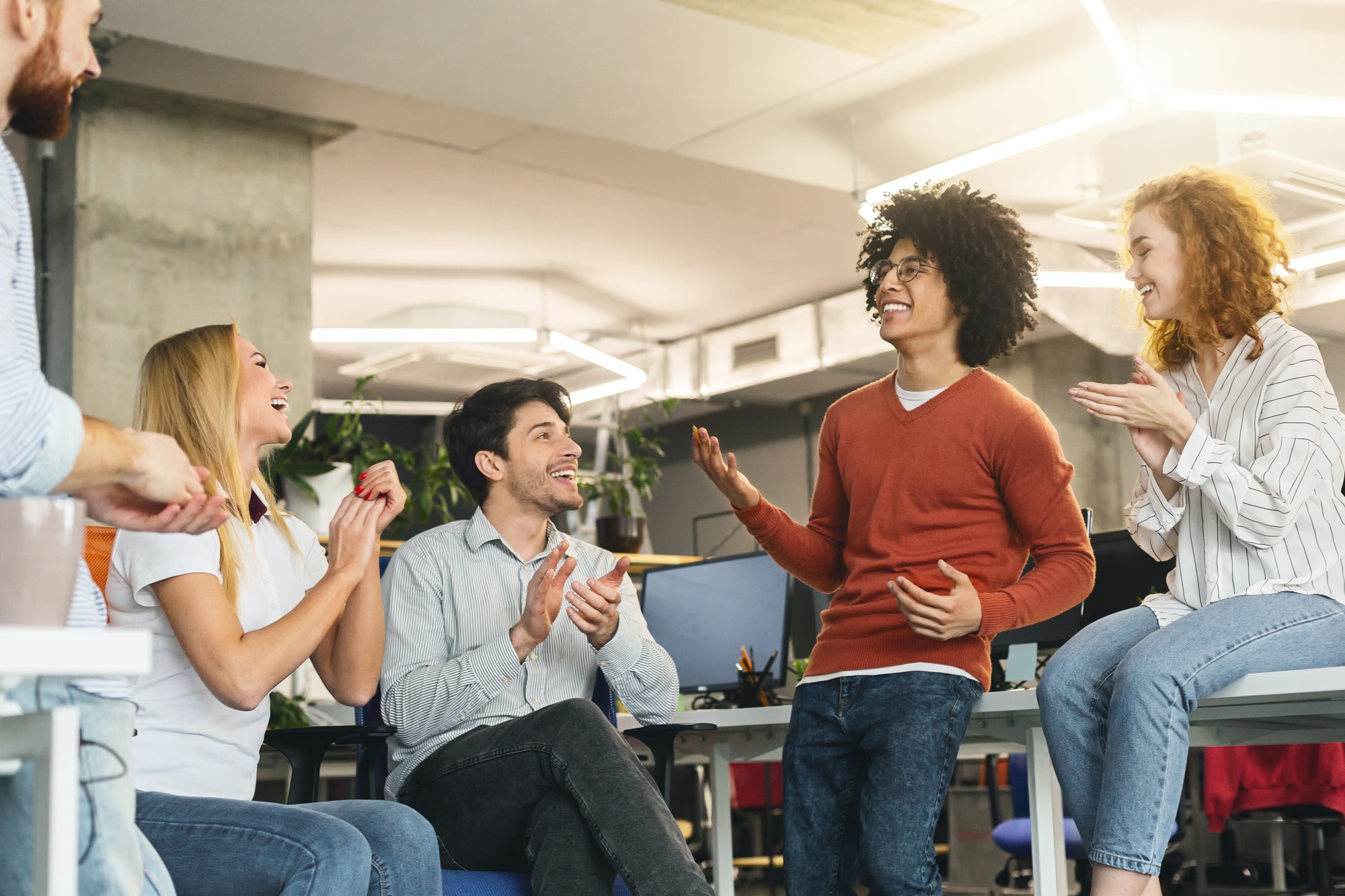 A group of people sitting around talking to each other.