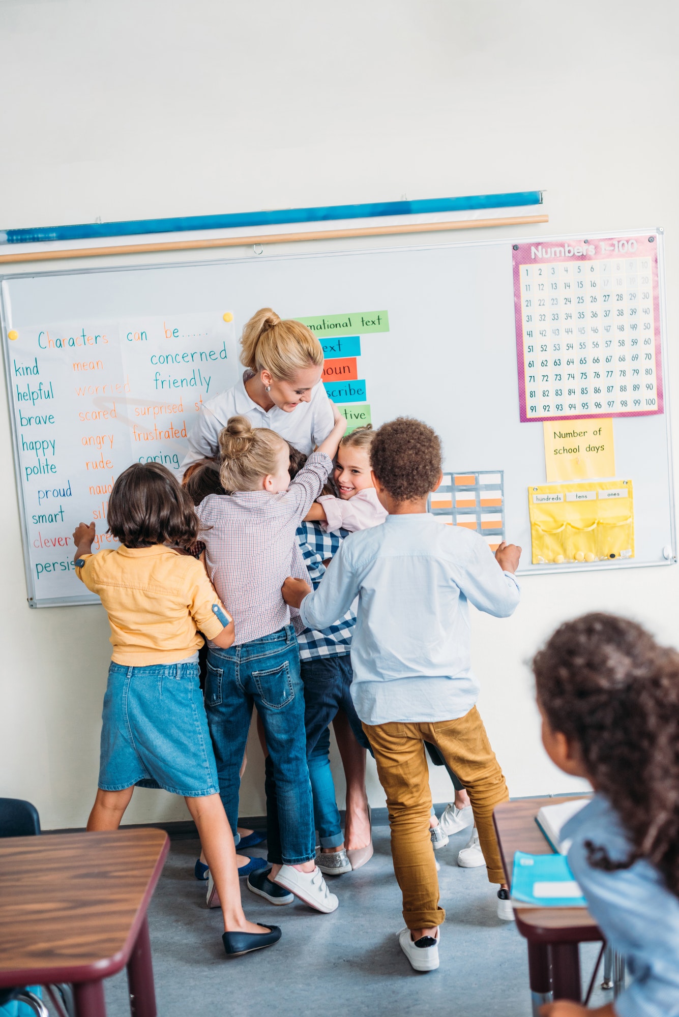 A teacher embracing their pupils in class