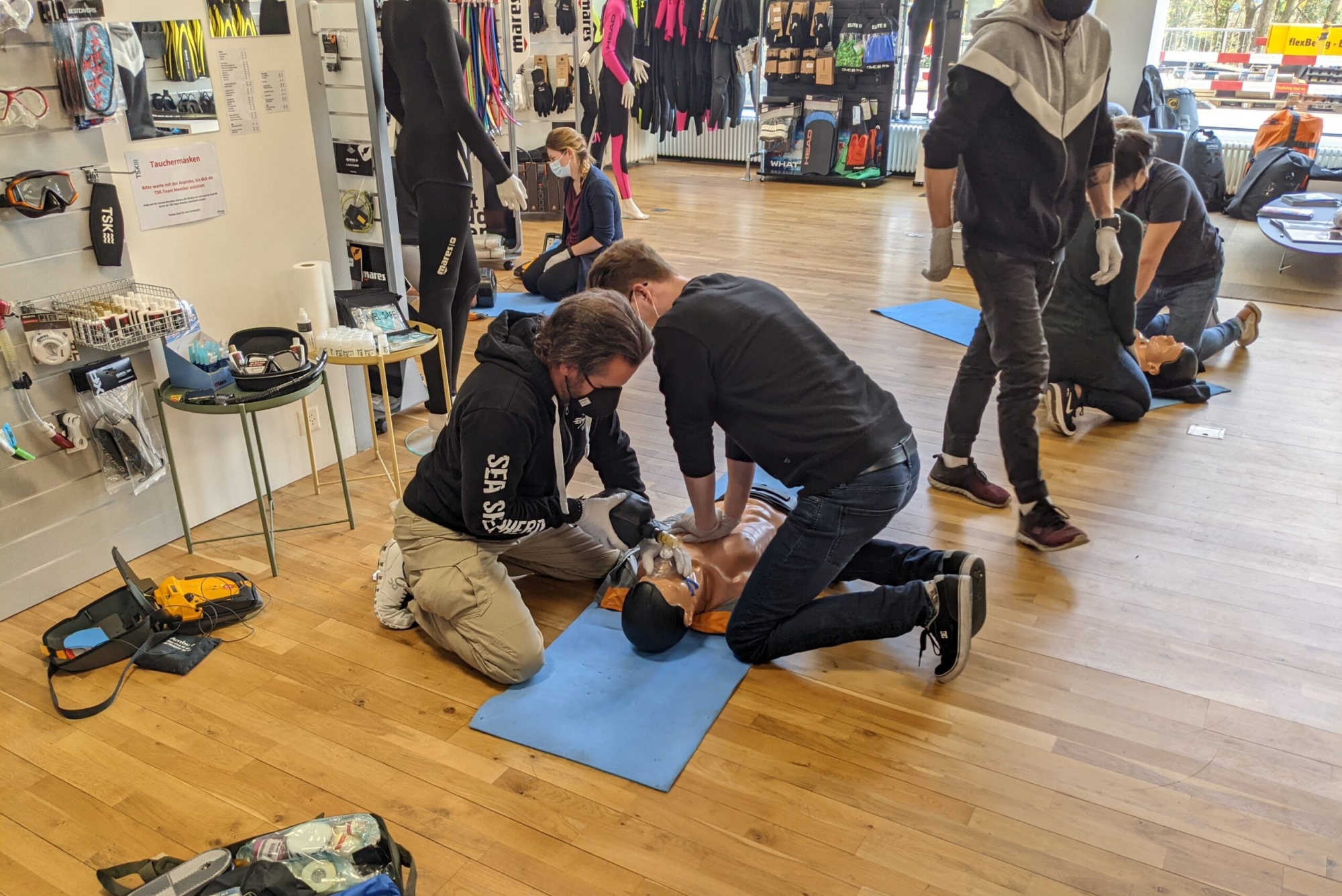 A group of people practicing cpr on the floor.